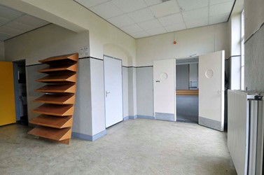 <p>Overzicht van de overloop op de verdieping in de richting van de kantine in de middenvleugel. Links naast de dubbele deuren van de kantine geeft een deur toegang tot de buffetruimte. </p>
